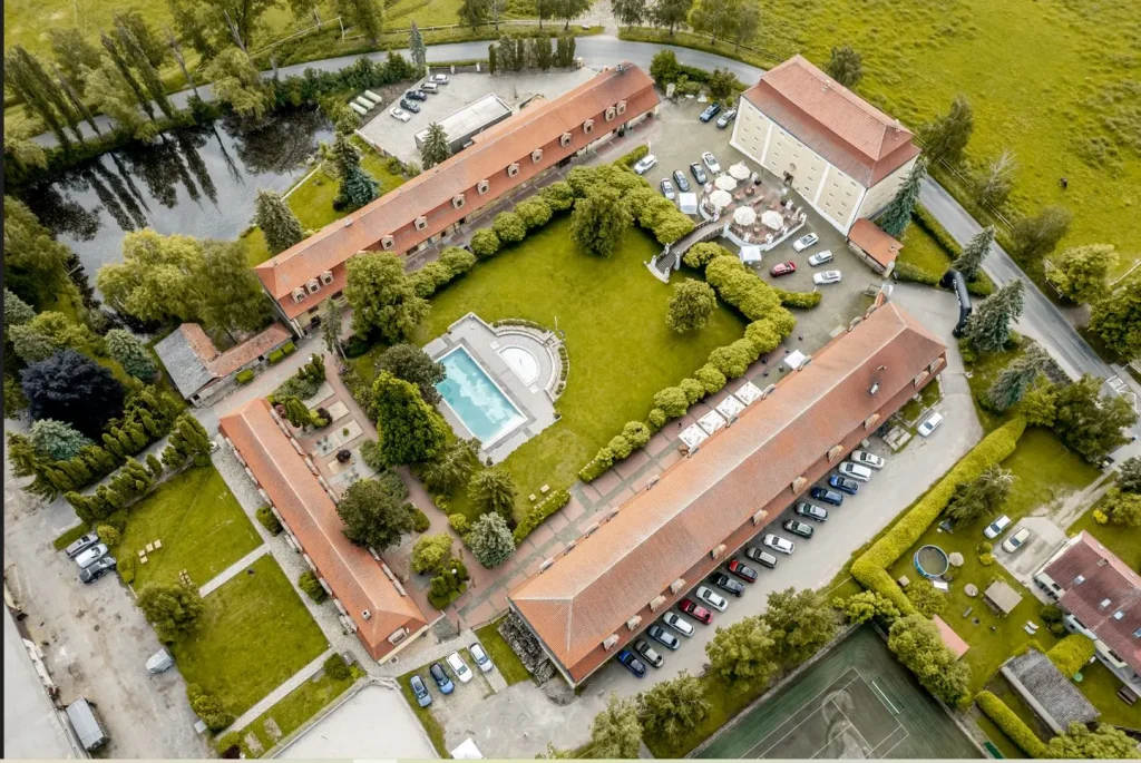 Dvůr Pecínov – Aerial view of the estate with the pool, garden, and parking