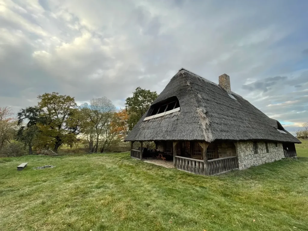 Dvůr Pecínov – The distillery, a stone building with a thatched roof set apart from the grounds