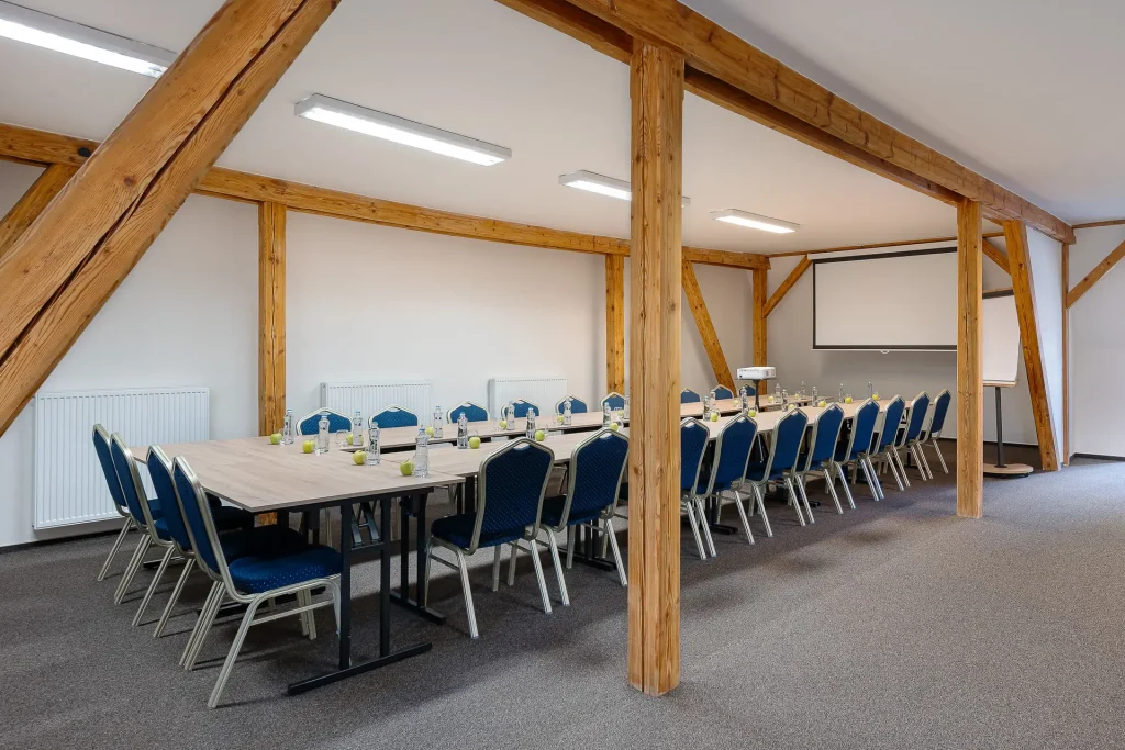 Dvůr Pecínov – Meeting room with a long table and a projection screen